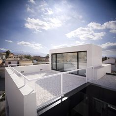 there is a roof that has a glass window on the top floor and white walls