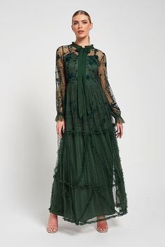 Embody enchanting elegance with Ivy. Realised in a deep green hue, this bewitching maxi dress is partially lined, showcasing tonal embroidered detailing. Tiered with ruffled trim, this long sleeved dress is complete with a self tie pussybow neckline. Dark Green Long Sleeve Dress, Cape Dresses, Sleeved Maxi Dress, Perfect Wedding Guest Dress, Wedding Dress Code, Winter Wedding Outfits, Green Long Sleeve Dress, Frock And Frill, Tonal Embroidery