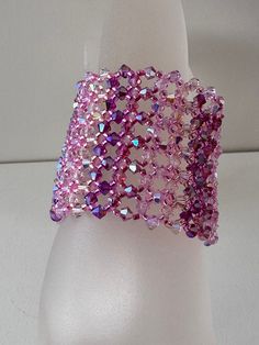 a white mannequin head with a pink bracelet on it's arm and purple sequins in the middle