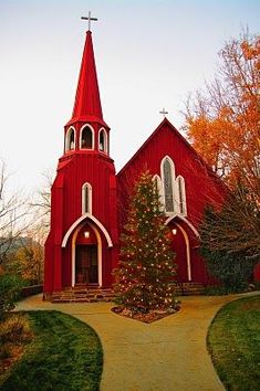 a red church with a christmas tree in front