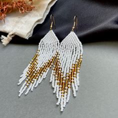 ELEGANT BEADED EARRINGS - WHITE AND GOLD These sophisticated beaded earrings are crafted from high-quality Czech beads, adding vibrancy and elegance to your look. Perfect for both special occasions and everyday wear, the classic combination of white and gold makes these earrings a versatile addition to any style. Each bead is carefully woven by hand to create a refined look, ensuring you're wearing and that is truly unique earrings. Add these handmade jewelry to your collection and see how they Jewelry Cute, Beaded Fringe, Earrings White, Czech Beads, Earrings Boho, Unique Earrings, Bridal Earrings, Boho Earrings, Mom Gift