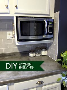 a kitchen with white cabinets and gray counter tops