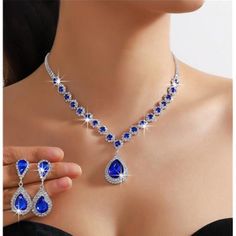 Elevate Your Sophistication With Our 2-Piece Simulated Diamond Teardrop Necklace And Earrings Set, Featuring Striking Blue Sapphire Lab-Created Crystals. This Elegant Jewelry Set Combines The Timeless Brilliance Of Simulated Diamonds With The Vivid Allure Of Deep Blue Sapphires. The Teardrop-Shaped Necklace Gracefully Adorns Your Neckline With Sparkling Simulated Diamonds, While The Blue Sapphire Lab-Created Crystals Add A Rich And Captivating Touch. Complementing The Necklace, The Matching Earr Blue Crystal Jewelry With Matching Earrings, Blue Crystal Jewelry Sets For Gifts, Blue Jewelry Sets For Wedding, Blue Teardrop Jewelry For Formal Occasions, Elegant Blue Necklace For Evening, Elegant Royal Blue Necklace For Party, Elegant Royal Blue Party Necklace, Blue Teardrop Jewelry With Matching Earrings, Blue Elegant Jewelry With Matching Earrings