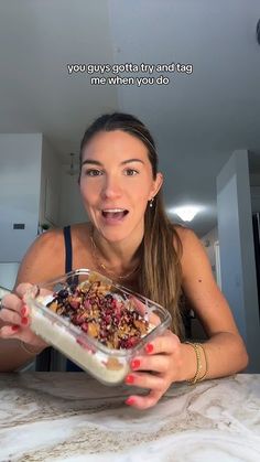 a woman sitting at a table with a bowl of food in front of her