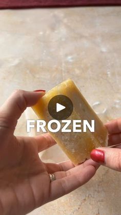 a woman holding a piece of frozen soap in her hand with the words frozen on it