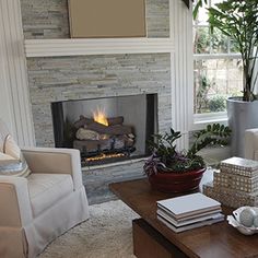 a living room filled with furniture and a fire place in the middle of a room