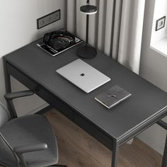 a laptop computer sitting on top of a black desk next to a chair and lamp