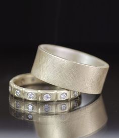 two gold wedding bands with diamonds on them