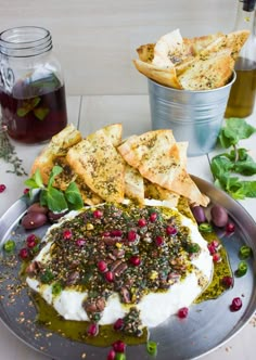 a plate with hummus, crackers and olives on it