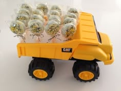 a yellow toy truck filled with cake pops