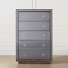 a metal filing cabinet sitting on top of a hard wood floor next to a white wall