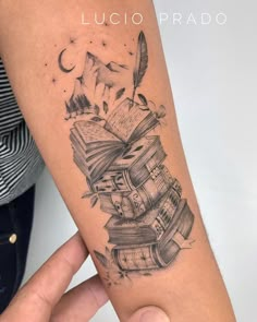 a person with a tattoo on their arm is holding a book and an ink pen