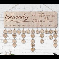 a wooden family sign hanging on a brick wall with hearts attached to the back of it