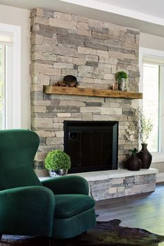 a living room filled with furniture and a stone fireplace