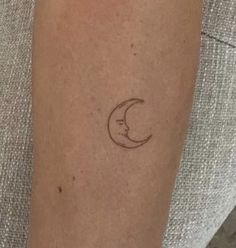 a woman's arm with a small crescent tattoo on the left side of her arm