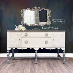 a white dresser with an ornate mirror on it's top and sideboard below