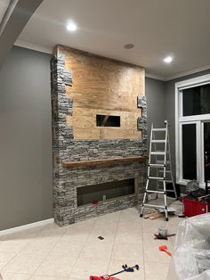 a living room with a fire place and ladders in front of the fireplace that is being built