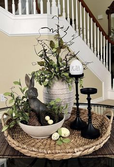 a basket with some plants in it on top of a table next to a candle holder