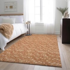 a bedroom with white walls and wooden floors, an orange rug is on the floor