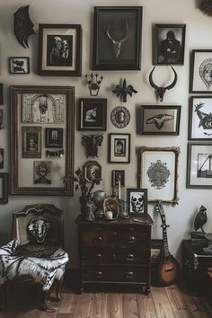 a room filled with lots of framed pictures on the wall next to a wooden floor