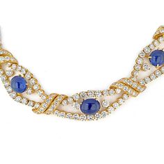 Discover the intersection of age-old tradition and contemporary design with this exquisite collar necklace from M. Gerard. Crafted in luxurious 18K yellow gold, this piece showcases nine mesmerizing cabochon-cut blue sapphires, each radiating a deep, alluring hue. The sapphires, ranging from approximately 15.5 x 8.5 x 5.0 to 7.7 x 7.6 x 4.5 mm, are elegantly complemented by round diamonds, creating a captivating openwork design that adds a touch of brilliance.With a total diamond weight of approximately 32.00 to 36.00 carats, this necklace exudes opulence and sophistication. The 14-inch length ensures a graceful drape around the neck, making it a statement piece for any formal occasion. Signed by M. Gerard and adorned with French assay and workshop marks, this necklace is a testament to fi Luxury Sapphire Necklace With Round Cut, Luxury Round Cut Sapphire Necklace, Luxury Heirloom Sapphire Jewelry, Luxury Handmade Sapphire Necklaces, Luxury Sapphire Necklaces With Polished Finish, Luxury Sapphire Gold Plated Jewelry, Luxury Sapphire Necklace With Bezel Setting, Exquisite Luxury Sapphire Necklace, Luxury Exquisite Sapphire Necklace