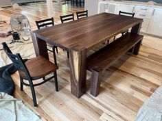 a wooden table and chairs in a room with hard wood flooring on the ground