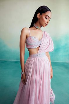 Introducing "bloomsy" - where elegance meets comfort! Our orchid pink bloomsy skirt saree is a one-of-a-kind creation, featuring a hand-embroidered bustier blouse adorned with mesmerizing double buttonhole stitches and shiny cutdanas. What sets this ensemble apart is its innovative design, allowing the dupatta to seamlessly attach to the skirt, granting you the look of a saree without the hassle of draping. Festive Draped Pink Lehenga, Pink Draped Choli With Unstitched Blouse, Traditional Pink Draped Lehenga, Traditional Draped Pink Lehenga, Pink Draped Set For Festive Occasions, Pink Draped Sets For Festive Occasions, Festive Draped Pink Set, Festive Pink Draped Set, Fitted Pink Pre-draped Saree For Summer