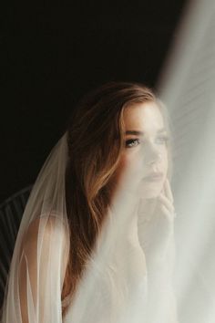 a woman wearing a veil looking out the window