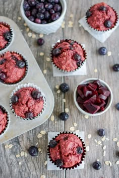 some blueberry muffins are sitting on a table next to other cupcakes