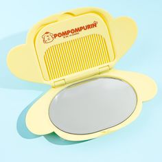 a yellow compact mirror sitting on top of a blue surface