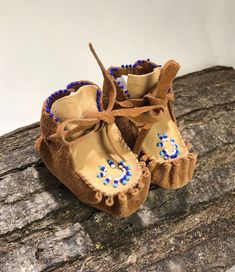 a pair of baby shoes sitting on top of a tree branch