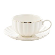 a white cup and saucer with gold trim