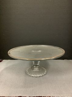 a glass cake plate sitting on top of a table