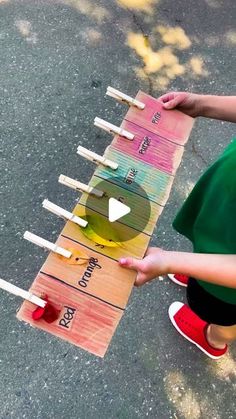 a young child is playing with a colorful board game on the street while another kid watches