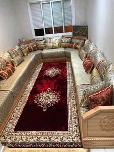 a living room filled with lots of couches and rugs on top of each other