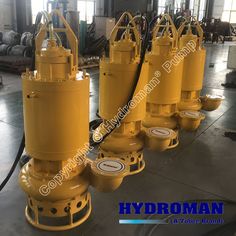 three yellow hydraulic submers sitting on top of a floor next to each other in a warehouse