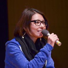 a woman holding a microphone up to her mouth