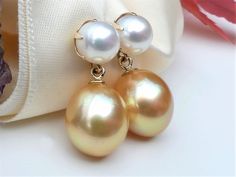 "Luxurious rich golden South Sea drop pearls dangling beneath six-prong set white freshwater pearl studs in solid 14k yellow gold. Timeless and classic pearl earrings. A fabulous addition to your jewelry collection. ✤ South Sea golden pearls are approx. 12.5 x 10.7mm, medium golden color. Very high luster, smooth surface with a few blemishes / very minor natural imperfection. ✤ South Sea pearl origin: Philippines. ✤ White freshwater pearls are 7mm, very high luster and smooth surface. ✤ Earrings Drop Pearl Earrings, Classic Pearl Earrings, Golden Pearl, Golden South Sea Pearls, Gold Pearl Earrings, Sea Pearl, White Freshwater Pearl, Sea Pearls, Golden Color