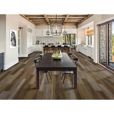 a large open kitchen and dining room with wood flooring that looks like it has been remodeled