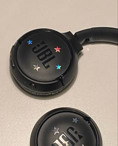 two black headphones sitting next to each other on a white counter top with stars