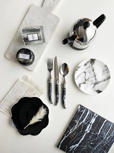 a table topped with black and white plates and silverware