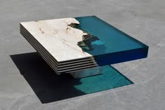 a table that is made out of marble and blue glass in the shape of a waterfall