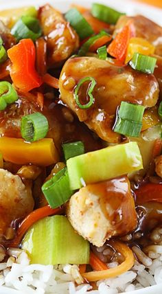 a white plate topped with rice covered in chicken and veggie stir - fry