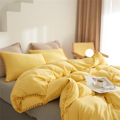 a bed with yellow comforters and pillows