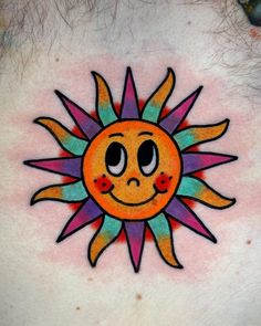 a sun tattoo on the back of a man's chest is painted with multicolored ink