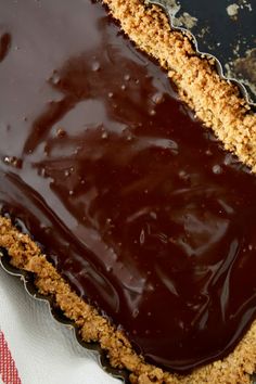 a chocolate pie with crumbs on it sitting on top of a white and red napkin