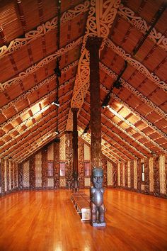 the inside of a building with wooden flooring and decorative wood carvings on the walls