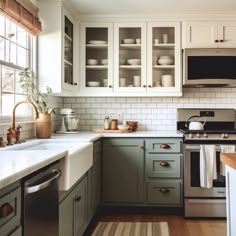 a kitchen with green cabinets and white counter tops