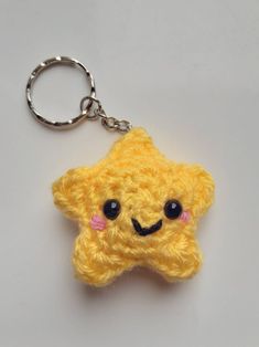 a crocheted yellow star keychain with a smiley face on the front