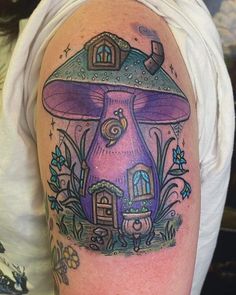 a mushroom house tattoo on the arm